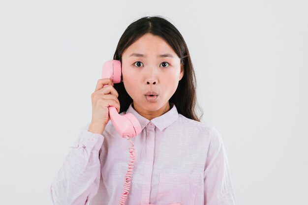 Foto gratuita mujer hablando por un teléfono rosa