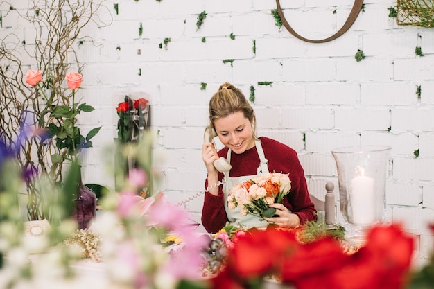 Mujer hablando por teléfono en tienda de flores