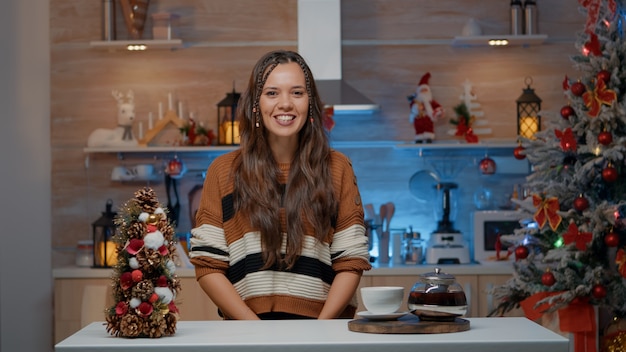 Mujer hablando por videollamada en cocina decorada en casa