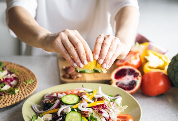 Una mujer hace un primer plano de ensalada de verduras frescas