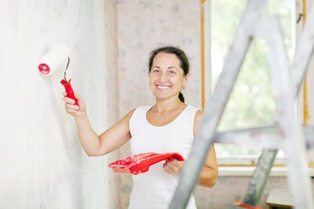 mujer hace reparaciones en casa