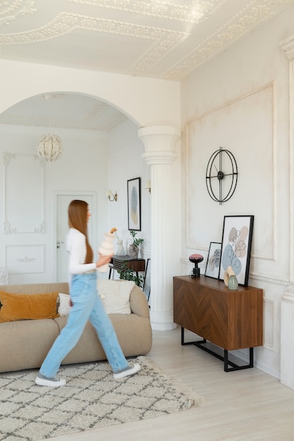 Mujer haciendo actividades diarias en una habitación mínimamente decorada.