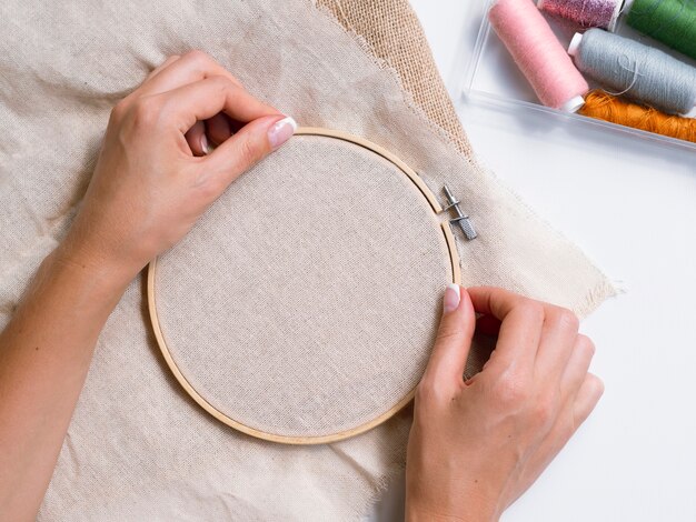 Mujer haciendo adornos con aros de madera y tela