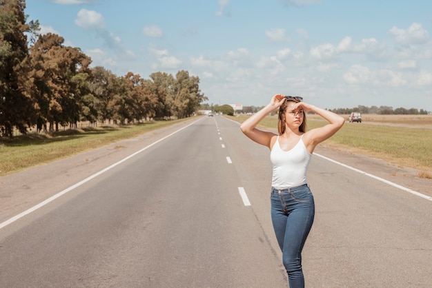 Foto gratuita mujer haciendo autostop en carretera