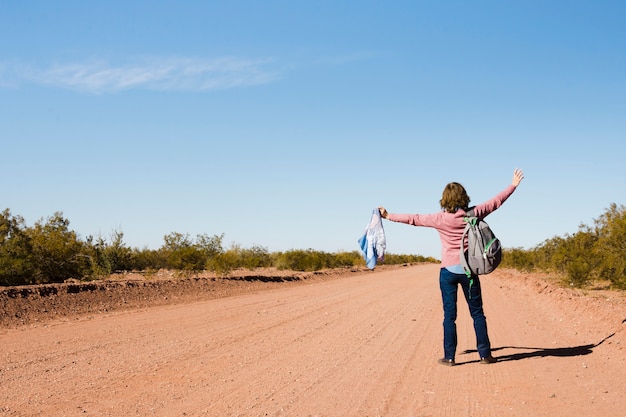 Mujer haciendo autostop en la naturaleza