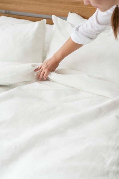 Mujer haciendo la cama por la mañana