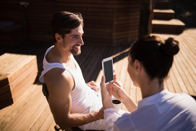 Mujer haciendo clic en la foto del hombre con el teléfono móvil