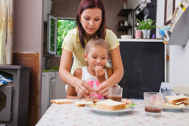 Mujer haciendo desayuno abeto hija