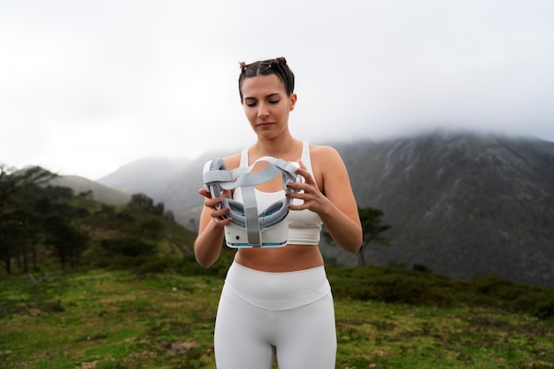 Foto gratuita mujer haciendo ejercicio al aire libre en la naturaleza con gafas vr