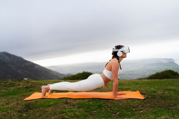 Mujer haciendo ejercicio al aire libre en la naturaleza con gafas vr