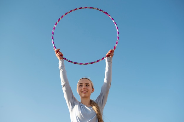 Foto gratuita mujer haciendo ejercicio con círculo de hula hoop