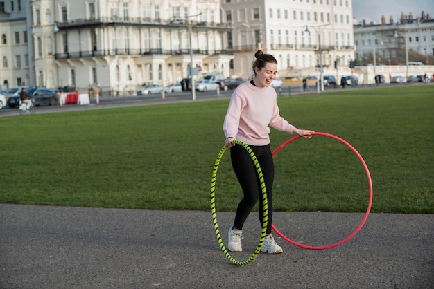 Foto gratuita mujer haciendo ejercicio con círculo de hula hoop