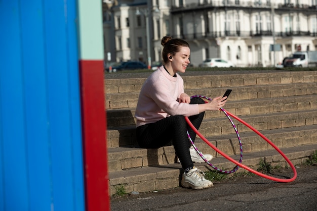 Foto gratuita mujer haciendo ejercicio con círculo de hula hoop