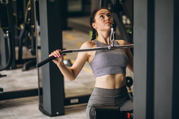 Mujer haciendo ejercicio en el gimnasio sola