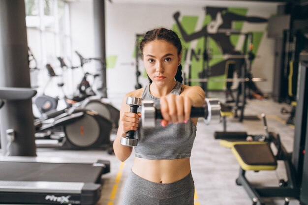 Mujer haciendo ejercicio en el gimnasio sola