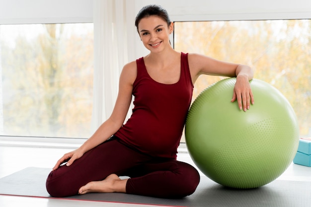 Foto gratuita mujer haciendo ejercicio con pelota de fitness durante el embarazo