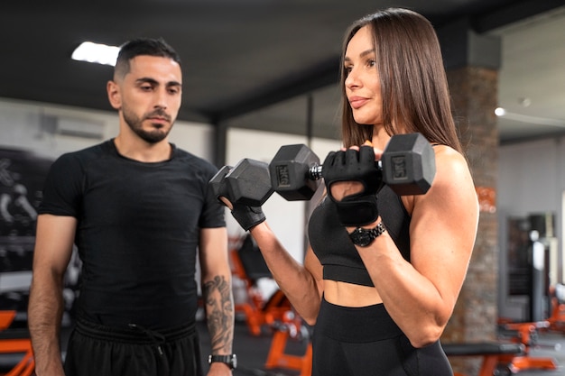 Mujer haciendo ejercicio con vista lateral de pesas