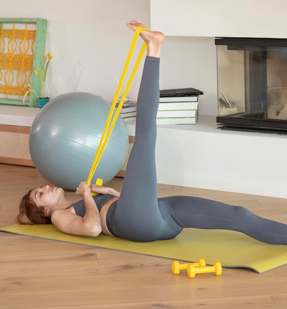 Mujer haciendo fitness en casa con banda