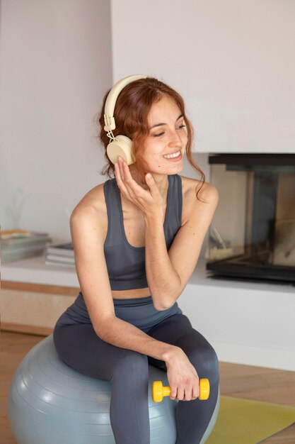 Mujer haciendo fitness en casa en bola