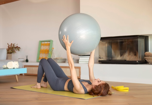 Foto gratuita mujer haciendo fitness en casa en mat