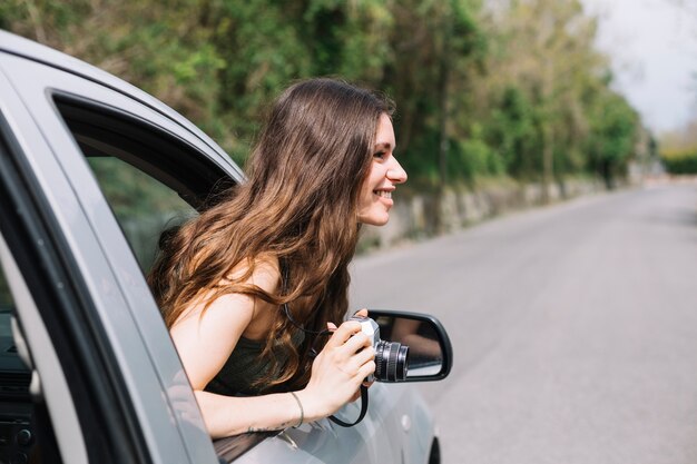 Mujer haciendo una foto por ventana de coche