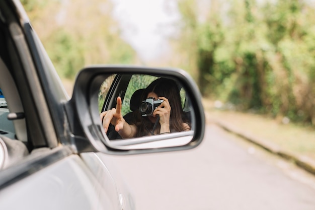 Mujer haciendo una foto por ventana de coche