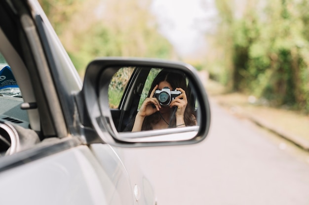 Mujer haciendo una foto por ventana de coche