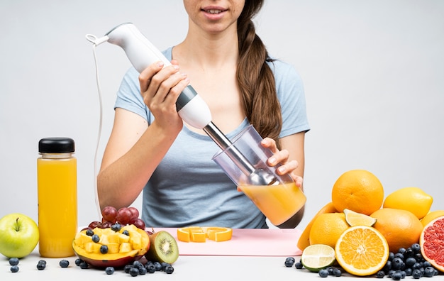 Foto gratuita mujer haciendo un jugo de naranja