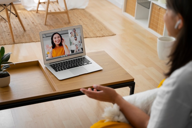 Foto gratuita mujer haciendo una llamada de video en casa en un dispositivo portátil