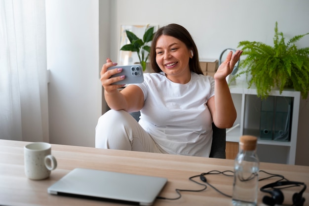 Mujer haciendo una llamada de video en casa con un dispositivo de teléfono inteligente