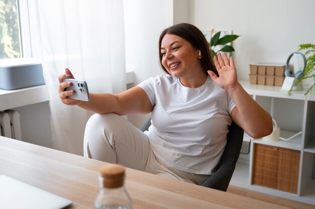 Mujer haciendo una llamada de video en casa con un dispositivo de teléfono inteligente