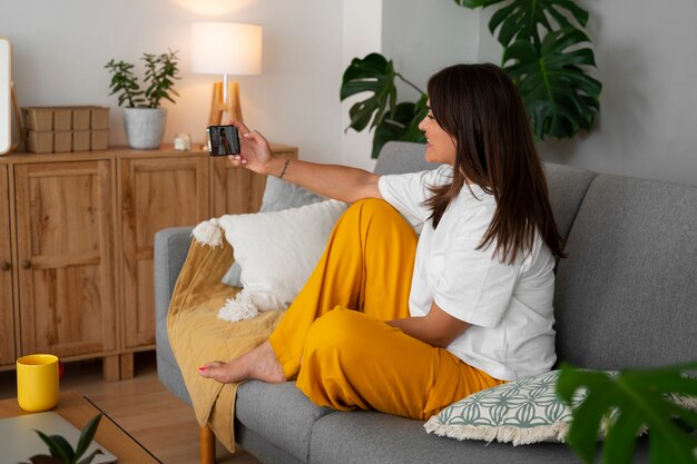 Mujer haciendo una llamada de video en casa con un dispositivo de teléfono inteligente