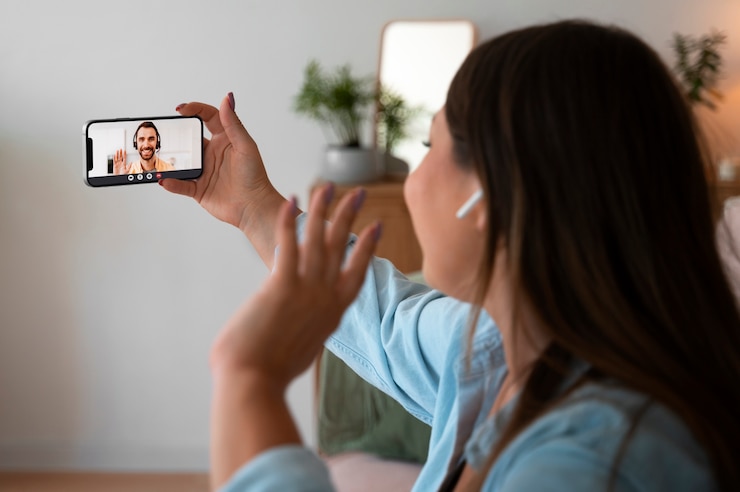Foto gratuito mujer haciendo una llamada de video en casa con un dispositivo de teléfono inteligente