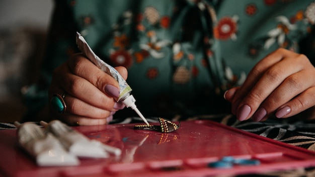 Mujer haciendo manualidades con la ayuda de pegamento.