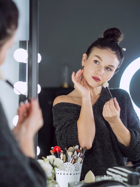 Mujer haciendo maquillaje tiro medio