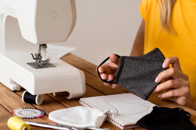 Mujer haciendo mascarilla usando la máquina de coser