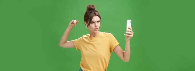 Mujer haciendo una mirada seria para tomar una selfie mientras escucha música en auriculares inalámbricos posando y