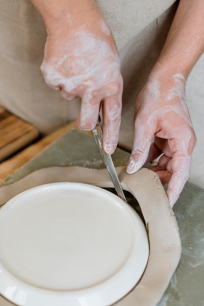 Mujer haciendo una olla de barro en su taller