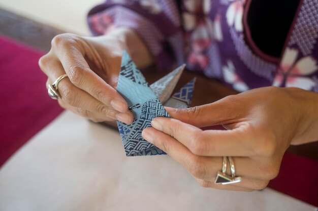 Mujer haciendo origami con papel japonés