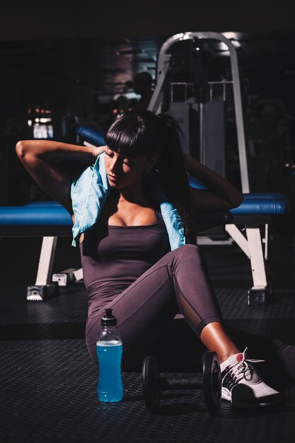 Mujer haciendo una pausa en gimnasio