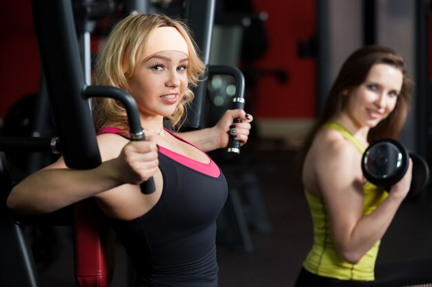 Mujer haciendo pecho en el gimnasio