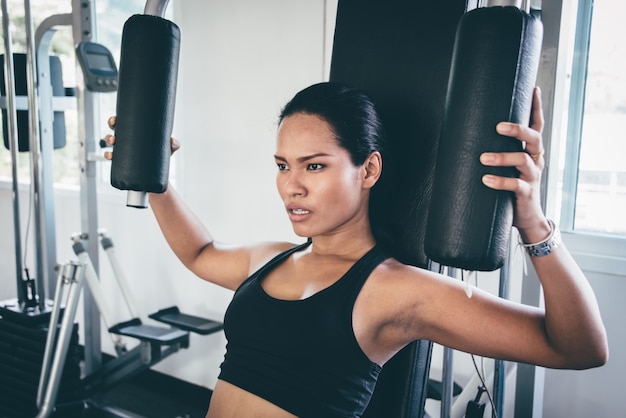 Mujer haciendo pecho en una máquina de gimnasio