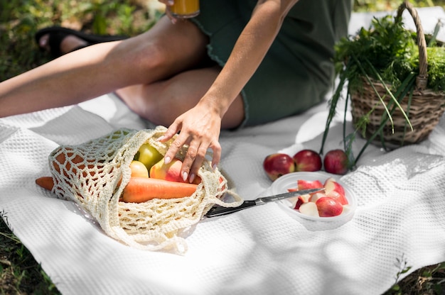 Mujer haciendo un picnic con bocadillos saludables