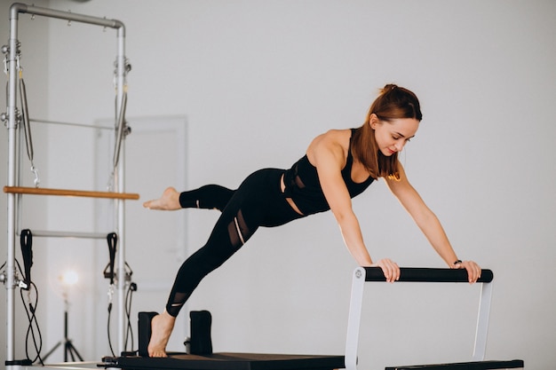 Mujer haciendo pilates en un reformador