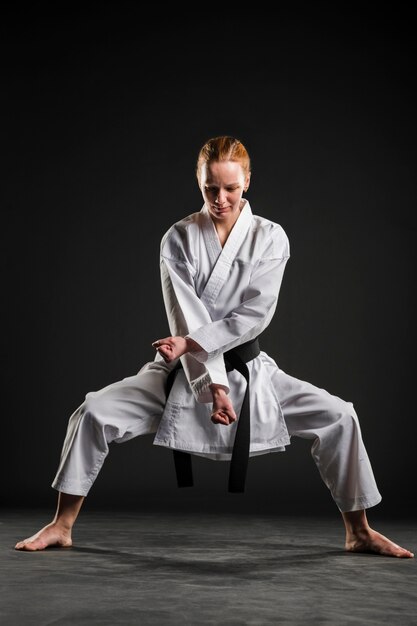 Mujer haciendo pose de karate tiro completo