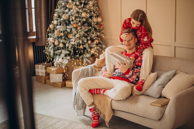 Mujer haciendo un regalo de Navidad a su novio