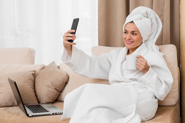 Mujer haciendo selfie en habitación de hotel