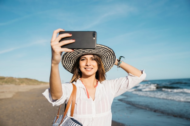 Mujer haciendo selfie en la orilla
