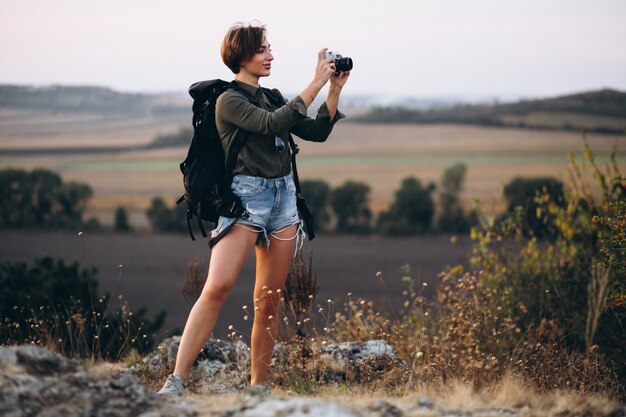 Mujer haciendo senderismo en las montañas y haciendo fotos.