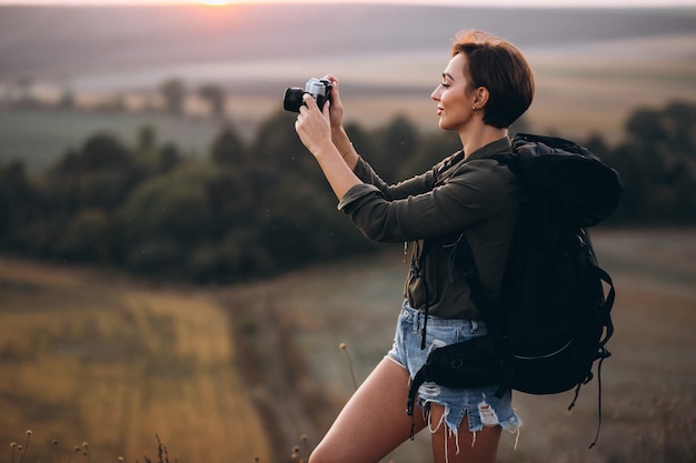 Mujer haciendo senderismo en las montañas y haciendo fotos.